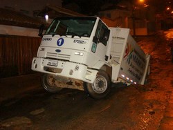 Caminhão de lixo fica preso em cratera